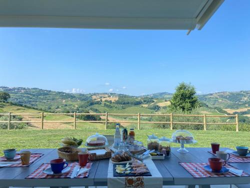 Cento的住宿－Poderino - a place to feel，一张带食物的蓝色桌子,享有田野的景色