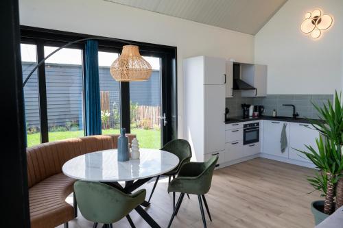 a kitchen and dining room with a table and chairs at 4 to 6 persons waterfront villa in Roelofarendsveen