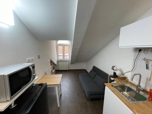 a kitchen and living room with a couch and a table at Happyhouse in Turin