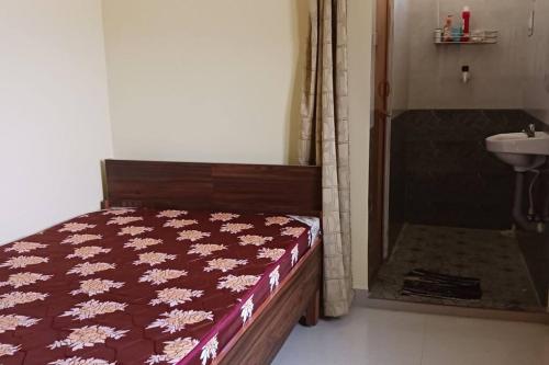 - une chambre avec un lit et une salle de bains pourvue d'un lavabo dans l'établissement A Sweet home Homestay Second Floor, à Palni