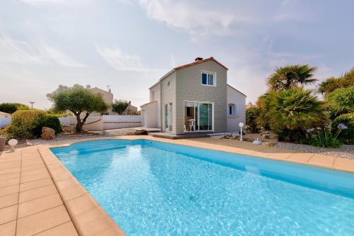 a swimming pool in front of a house at Paisible escale à Talmont-Saint-Hilaire avec piscine in Saint-Jean-dʼOrbetiers