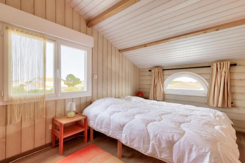 a bedroom with a large bed and a window at Paisible escale à Talmont-Saint-Hilaire avec piscine in Saint-Jean-dʼOrbetiers
