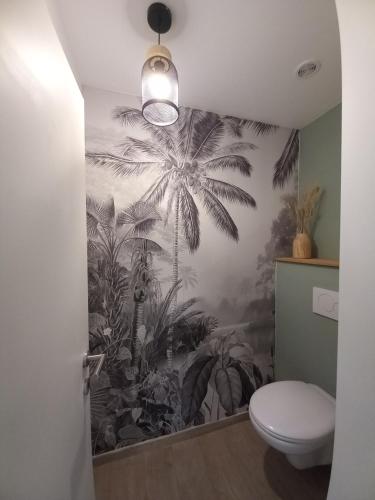 uma casa de banho com um mural de palmeiras em Les hauts de Meez em Dinant