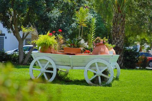 a white cart with potted plants in a yard at Garden View Two Bedroom Apartment in Caesar Resort & SPA, Long Beach in Perivolia tou Trikomou