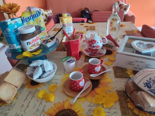 a table topped with cups and plates of food at INTERO APPARTAMENTO catania policlinico in Gravina di Catania