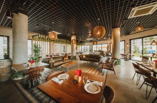 a restaurant with tables and chairs and a lobby at Garden View Two Bedroom Apartment in Caesar Resort & SPA, Long Beach in Perivolia tou Trikomou