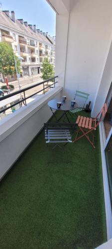 un balcon avec une table et des chaises sur un immeuble dans l'établissement Appartement hyper-centre, à Saint-Nazaire