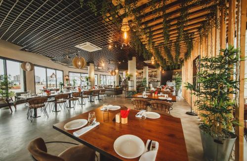 a restaurant with a table and chairs and tables and windows at Garden View Two Bedroom Apartment in Caesar Resort & SPA, Long Beach in Perivolia tou Trikomou