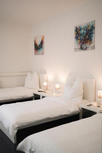 2 Betten in einem Zimmer mit zwei Lampen in der Unterkunft Ein, Zwei- oder Mehrbettzimmer/ Monteurszimmer in Leipzig