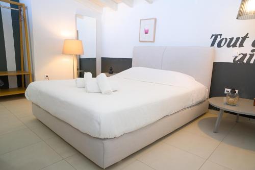 a large white bed in a room with a table at Ktima Faki, Olympus Mountain Accommodation & Retreat in Litochoro