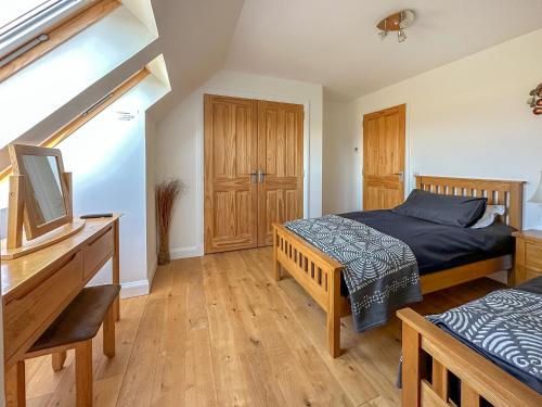 a bedroom with two beds and a desk with a television at Lurach House - Ukc6791 in Port Appin