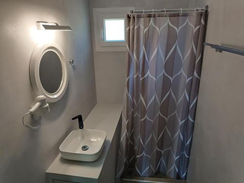 a bathroom with a sink and a shower curtain at Silver View Aprovato in Apróvaton