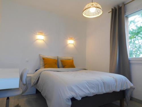une chambre avec un lit avec des oreillers jaunes et une fenêtre dans l'établissement Bel appartement 4 pièces, à Toulon