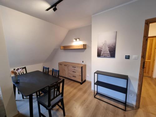 a dining room with a table and a desk at Ostoja in Ostrowo