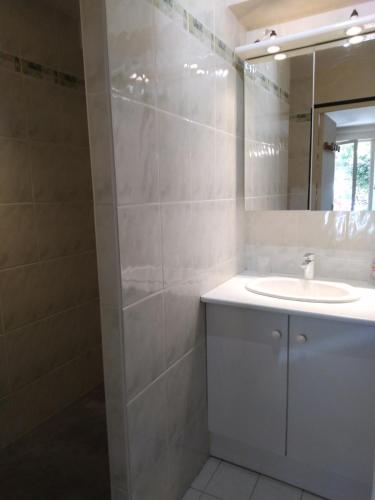 a bathroom with a sink and a mirror at Spacieuse maison de village climatisée avec jardin patio in Bessan
