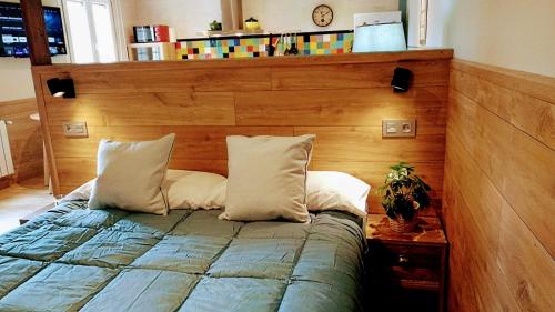 uma cama com uma cabeceira de madeira num quarto em Villa Natalia Loft Rural em Llanes