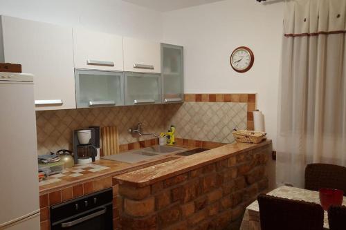 a kitchen with a brick counter top and a clock at Apartments Belvedere - A1 in Nečujam