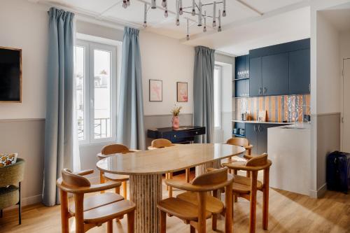 uma cozinha com uma mesa de jantar e cadeiras em Edgar Suites Montmartre - Paul Albert em Paris