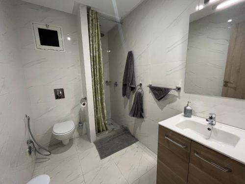 ASAMA appartement avec piscine في مراكش: حمام ابيض مع مرحاض ومغسلة