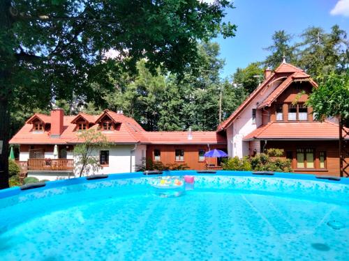 a house with a swimming pool in front of a house at Dom Natury in Karpacz