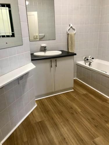 a bathroom with a sink and a tub and a mirror at Salt Rock Ocean Views in Sheffield Beach