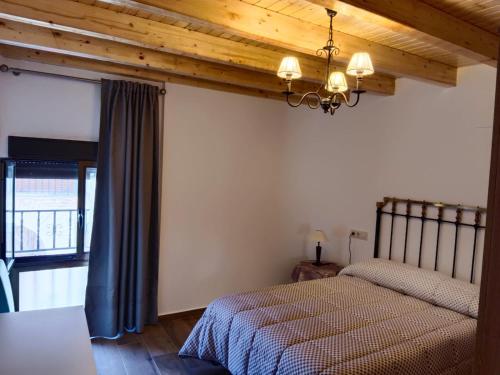1 dormitorio con 2 camas y techo de madera en Casa Marcelinas por habitaciones en Samper del Salz