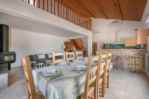 une salle à manger et une cuisine avec une table et des chaises dans l'établissement Maison 10p au calme 200m mer, à La Plaine-sur-Mer