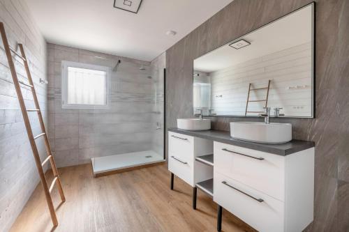 une salle de bain avec deux lavabos et un miroir dans l'établissement Maison 10p au calme 200m mer, à La Plaine-sur-Mer