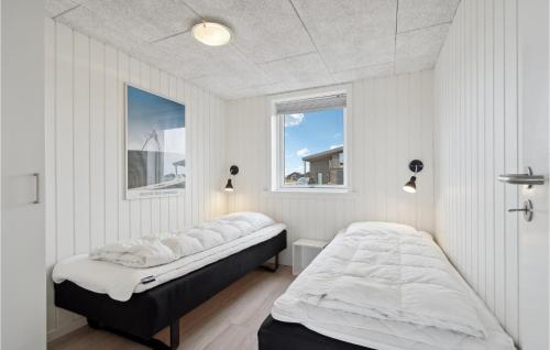 a bedroom with two beds and two windows at 2 Bedroom Beautiful Home In Ringkbing in Søndervig