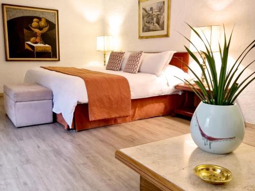 a bedroom with a bed and a vase with a plant at Antara Hotel & Suites - Miraflores in Lima