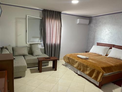 um quarto de hotel com uma cama e um sofá em Hotel MASSINE 