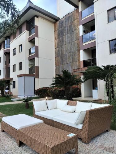 a couch and a coffee table in front of a building at L316 LA Apartamento aconchegante resort à beira lago in Brasilia