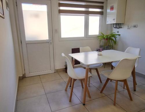 ein Esszimmer mit einem weißen Tisch und Stühlen in der Unterkunft Yoppen: Duplex 2 dormitorios en Ushuaia in Ushuaia