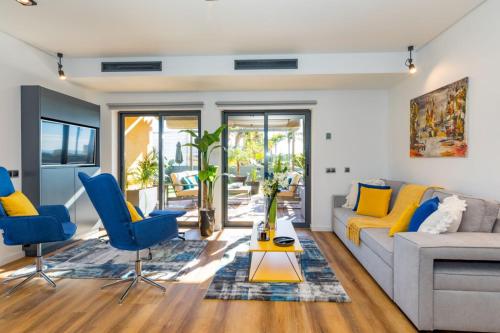 a living room with a couch and blue chairs at Stunning Exclusive Parque Atlântico in Quarteira