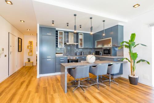 a kitchen with blue cabinets and a table with chairs at Stunning Exclusive Parque Atlântico in Quarteira