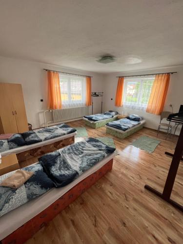 Habitación con 4 camas y ventanas. en Turistická ubytovňa u Frajta, en Telgárt