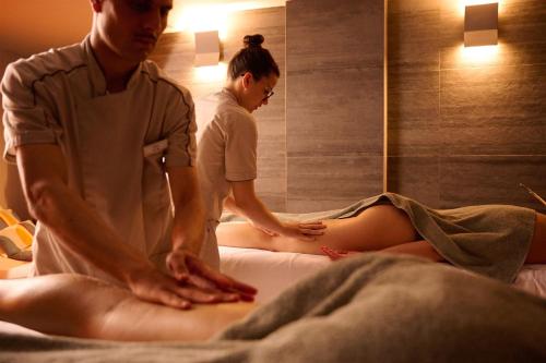 a man and woman getting a massage in a room at Castello Bonaria Wine & Spa Resort in Campiglia Marittima