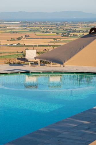a pool with a chair and a blanket over it at Castello Bonaria Wine & Spa Resort in Campiglia Marittima