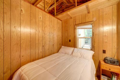 Bett in einem Holzzimmer mit Fenster in der Unterkunft Waterfront Lake Cabin Close to Boating and Fishing! in Lake