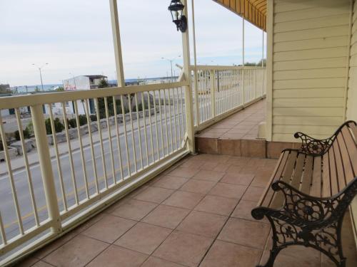 un portico con due panchine e una ringhiera di Villa Nova Motel a Wasaga Beach