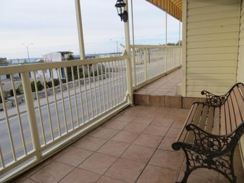 a porch with two benches and a railing at Villa Nova Motel in Wasaga Beach