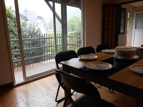 a dining room with tables and chairs and a balcony at appartement 8 places in Laruns