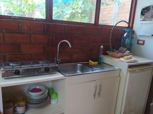 cocina con fregadero y fogones en Casita Grau 2! Naturaleza y confort con Agua caliente,cocina y frigobar, en Tarapoto
