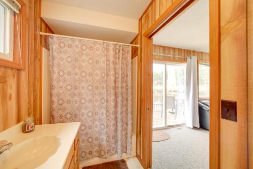 a bathroom with a sink and a door to a patio at Lake Vacation Rental with Deck and Gas Grill! in Lake