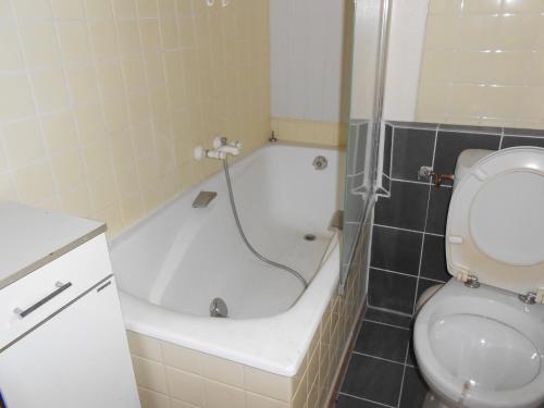 y baño con bañera junto a un aseo. en appartement 8 places en Laruns