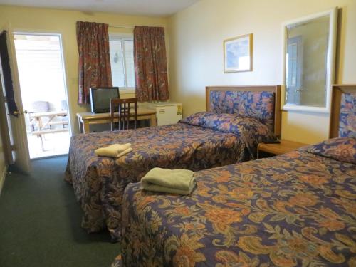 Un pat sau paturi într-o cameră la Villa Nova Motel