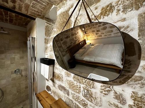 a bedroom with a mirror on a brick wall at Ego HOME in Cluj-Napoca