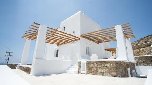 a white villa with stairs leading up to it at Elia Spirit Villas and Suites by Live&Travel in Elia Beach