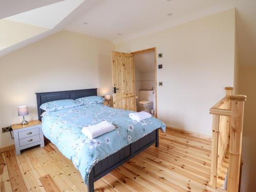 a bedroom with a bed and a wooden floor at Hen Blaid in Oswestry