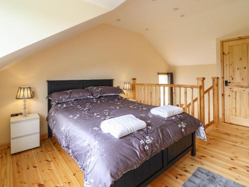 Schlafzimmer mit einem Bett und Holzboden in der Unterkunft Old Cart House in Oswestry
